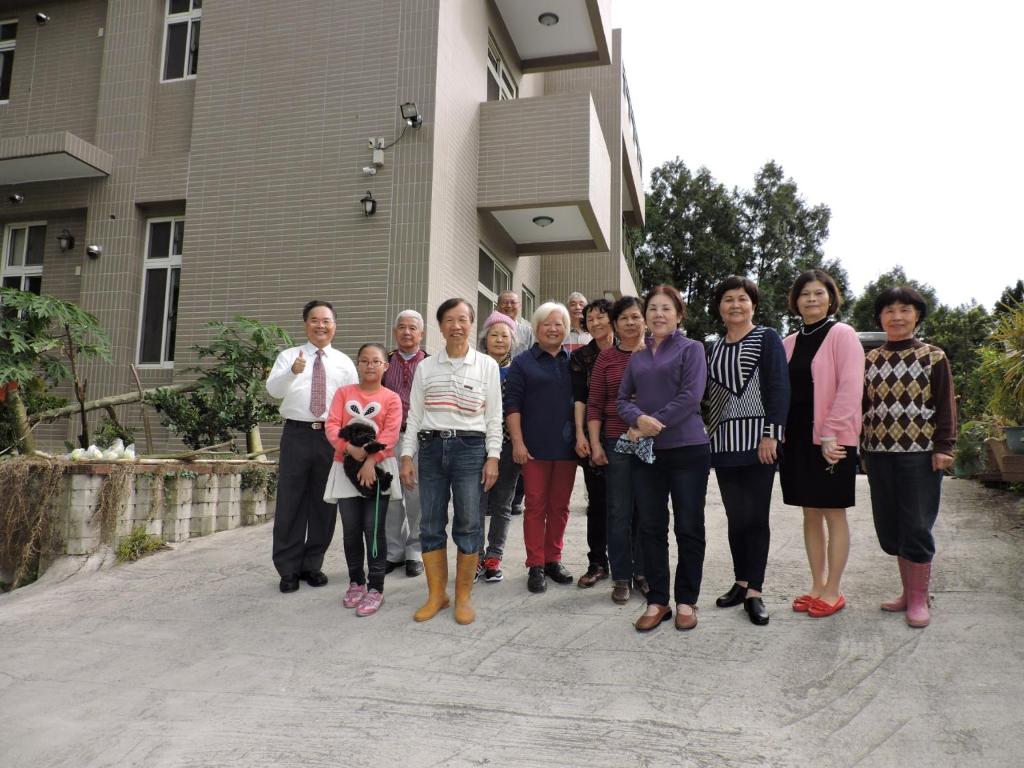 a group of people standing in front of a house at Shan Hu Lian Homestay in Zhuolan