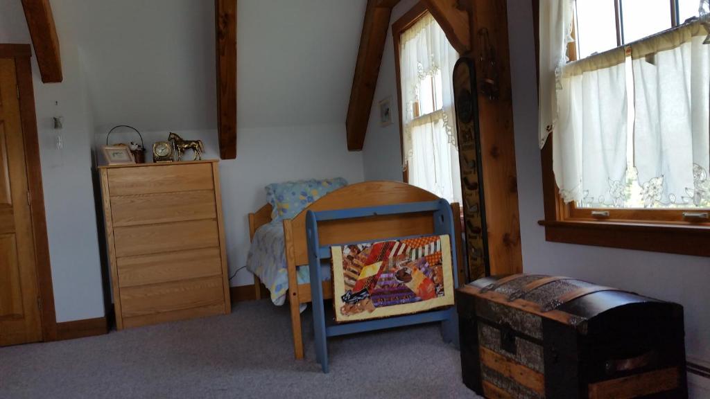 a bedroom with a table and a chair and windows at Clover Hill Farm & Country Inn in Williamstown