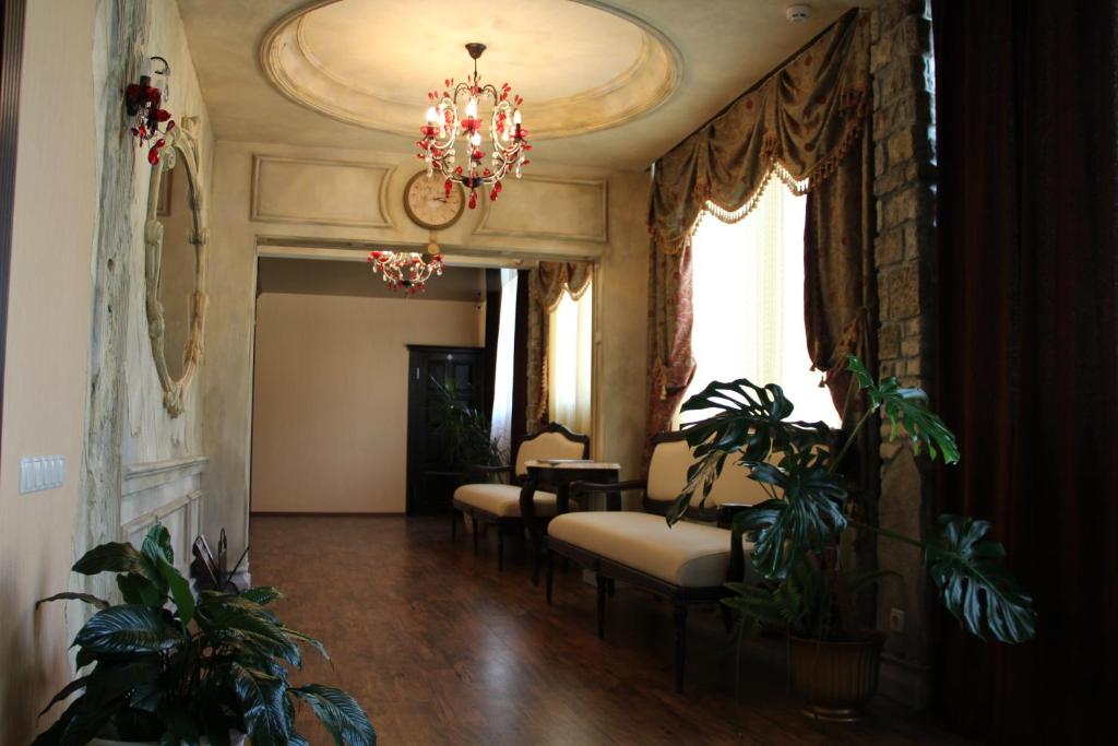 sala de estar con sillas y lámpara de araña en Hotel Meduza, en Járkov