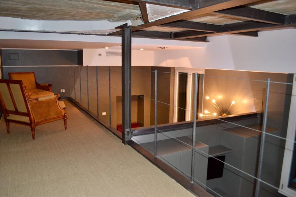 Carducci 2 - Charming & Cozy Apartment في ميلانو: غرفة بها كرسي ومكتب في مبنى