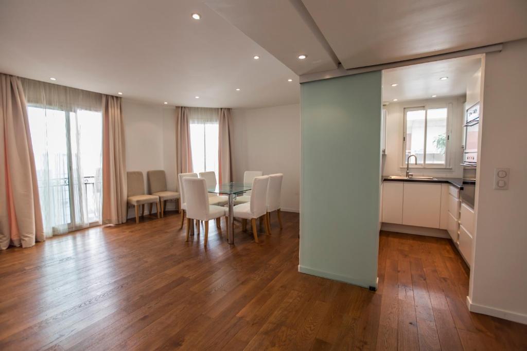 une cuisine et une salle à manger avec une table et des chaises dans l'établissement Imperial Apartment by Connexion, à Cannes