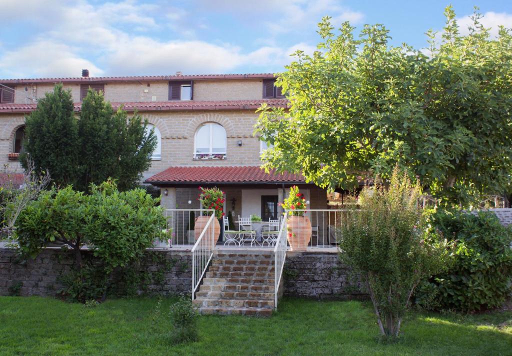 a house with a staircase in front of a yard at Le3sorelle in Monterosi