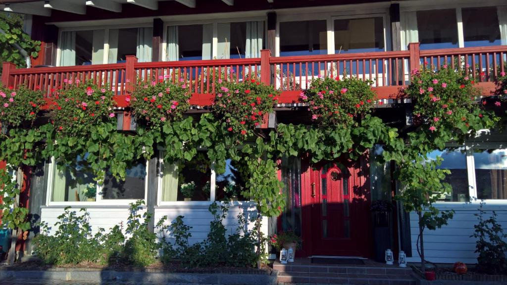 a house with a red door and flowers on it at Familienzimmer Bastian in Haibach