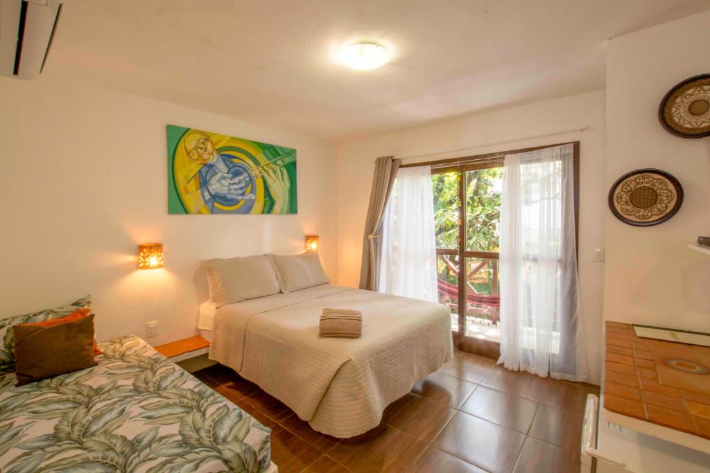 a bedroom with a bed and a window at Pousada Borboleta in Morro de São Paulo