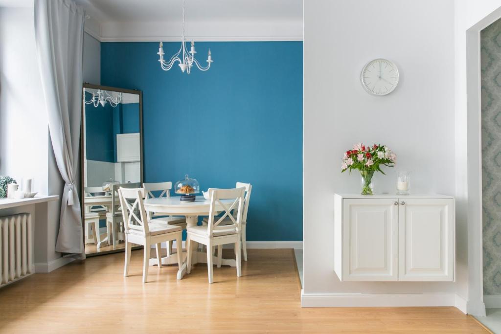 une salle à manger avec une table et un mur bleu dans l'établissement Apartament Rozbrat, à Varsovie