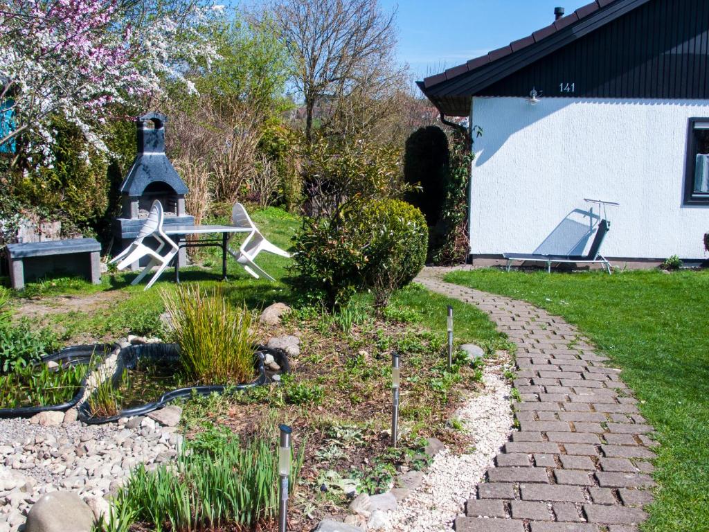 un jardín con un camino de piedra que conduce a una casa en Im Herzen der Natur, en Herdwangen-Schönach