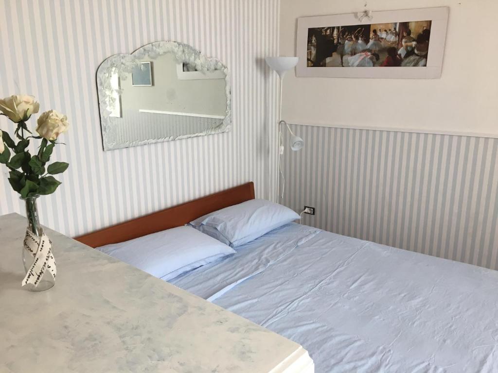 a bedroom with a bed and a vase of flowers on a table at Casa Maria in Salerno