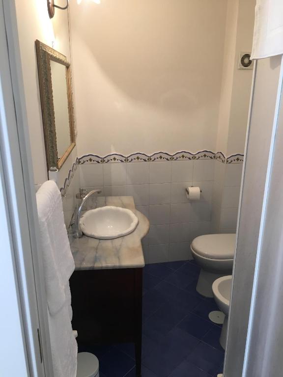 a bathroom with a sink and two toilets at Casa Maria in Salerno