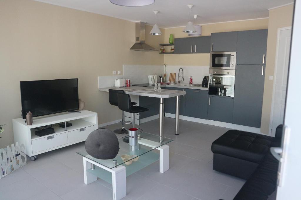 a living room with a table and a kitchen at Maison indépendante in Marseille