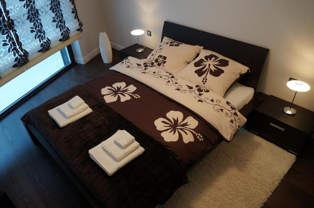 sypialnia z łóżkiem z brązową i białą kołdrą w obiekcie Apartament W&J w Szklarskiej Porębie