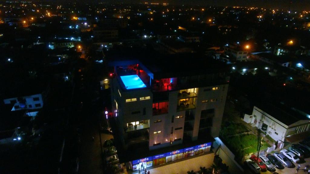 un edificio con luces por la noche en Suncity Hotel Apartment en Accra
