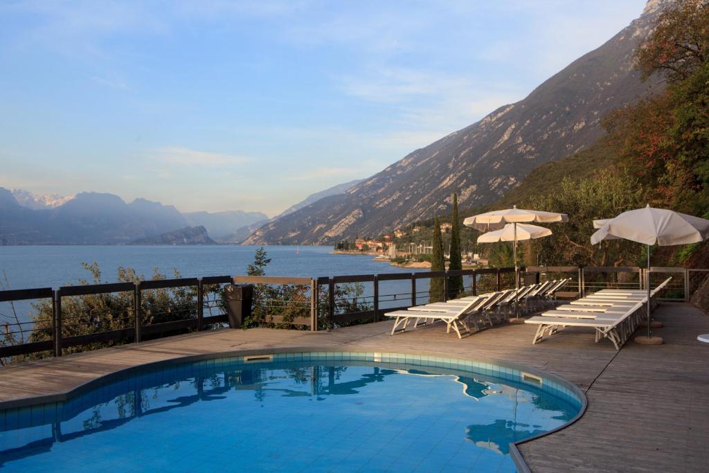 a swimming pool with chairs and a view of a lake at Piccolo Hotel in Malcesine