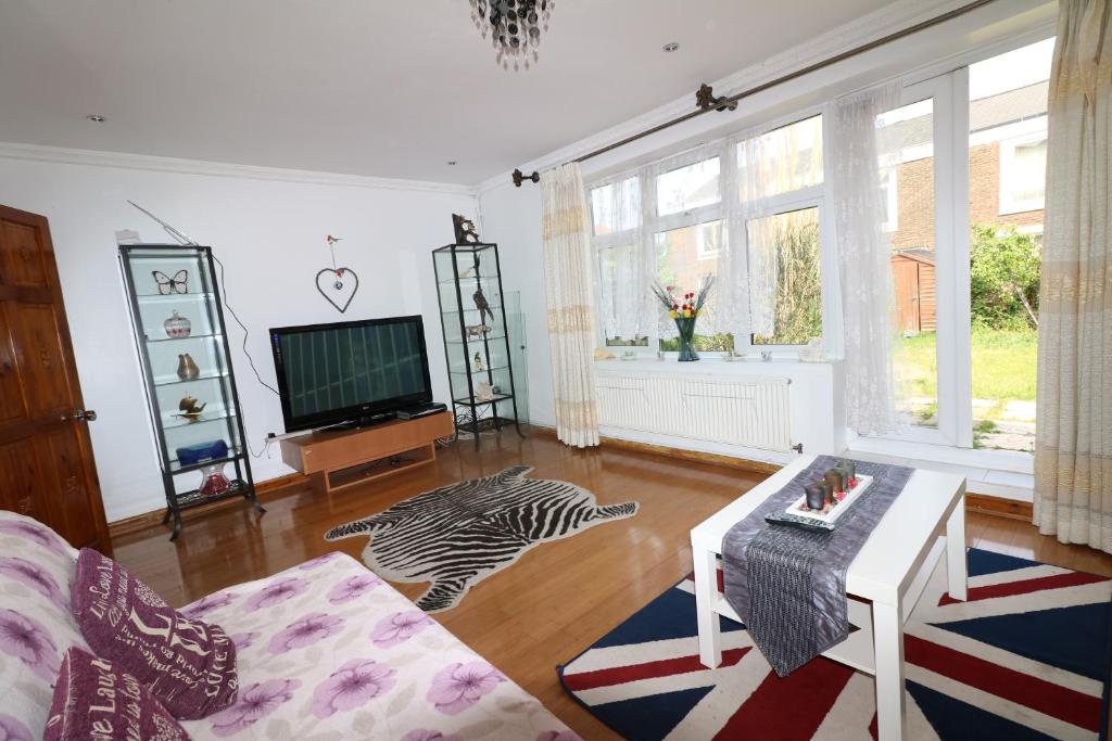 a living room with a television and a zebra rug at Abbey Private House with Lovely Garden in London