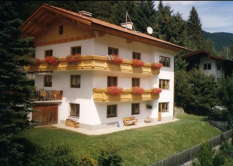 a large white building with flowers on the balcony at Ferienwohnung Wolf in Trins