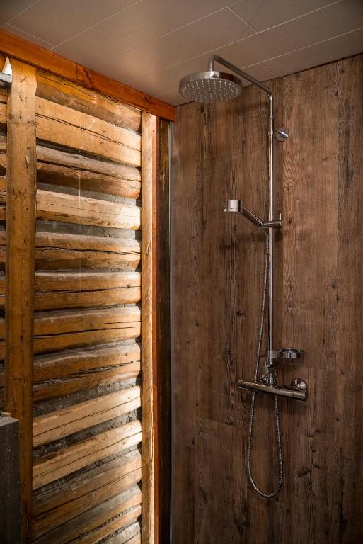 a bathroom with a wooden wall with a shower at Tangs in Ísafjörður