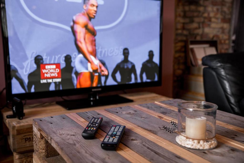 a table with a television and remote controls on it at Tangs in Ísafjörður