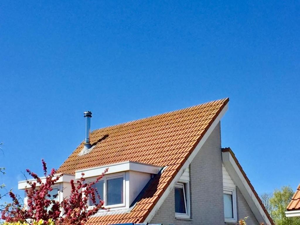 スカーレンデイケにあるFerienhaus Nordseeliebeの赤瓦屋根の家屋
