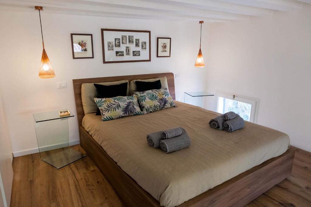 una camera da letto con un grande letto con due cuscini sopra di Ca'Tintoretta a Venezia