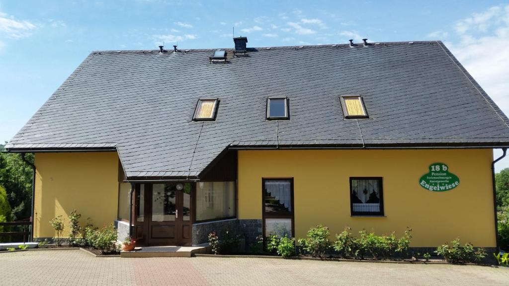 a yellow building with a gray roof at Pension Gerlach in Seiffen