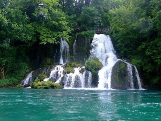 a waterfall in the middle of a body of water at Viola i Detelina Apartments in Perućac