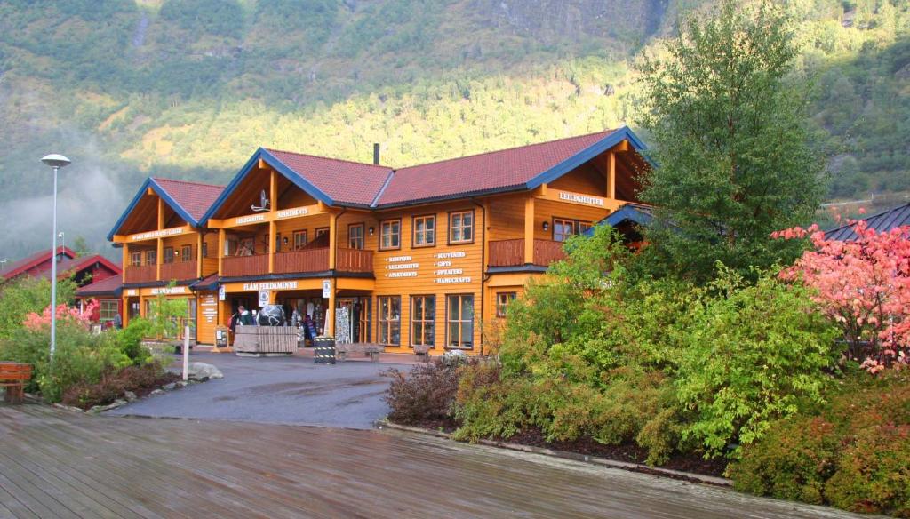 a large wooden house with a mountain in the background at Flåm Ferdaminne in Flåm