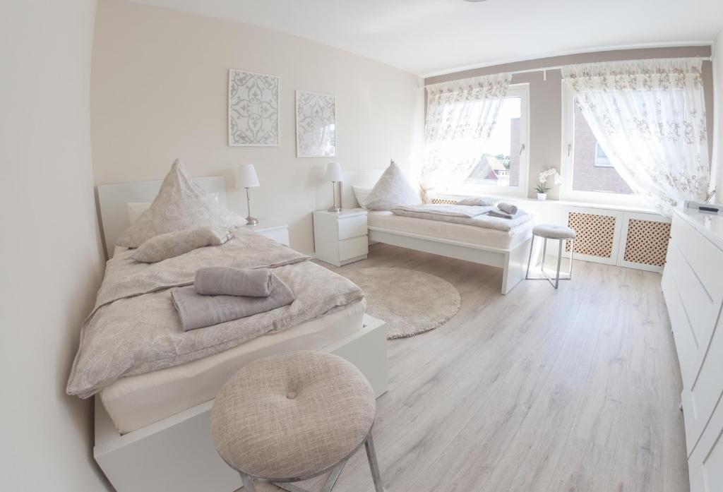 a white bedroom with a large bed and a window at Joel Living Apartment in Hannover