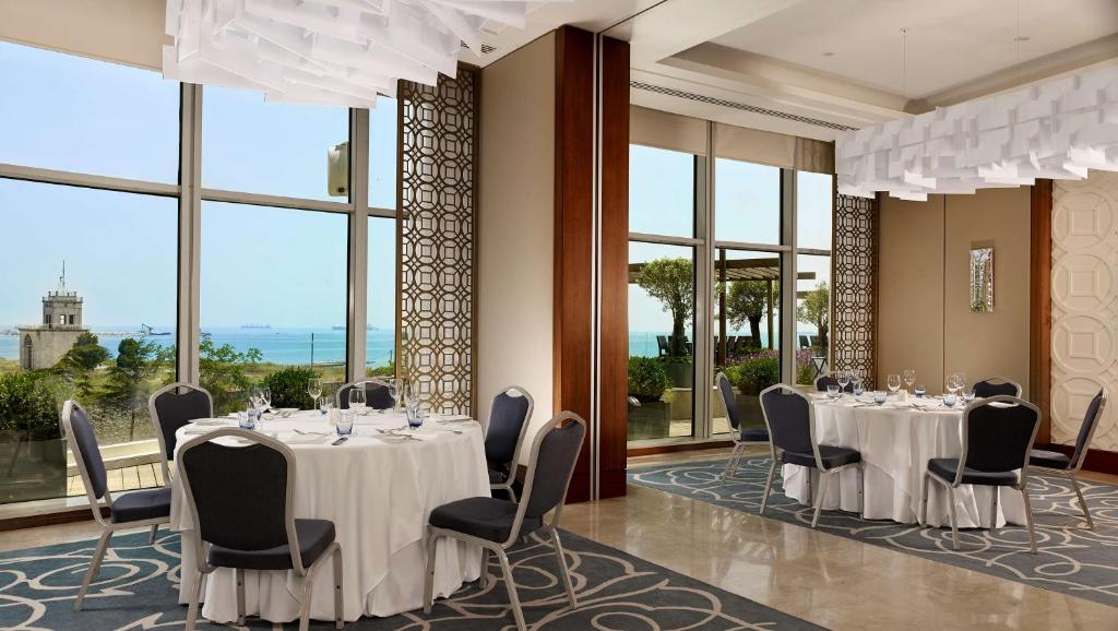 una sala de conferencias con mesas, sillas y ventanas en Hyatt Regency Istanbul Atakoy, en Estambul