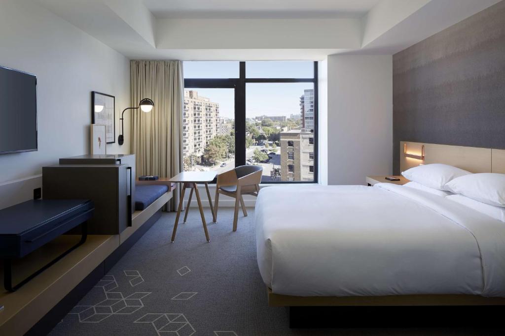 オタワにあるAndaz Ottawa Byward Market, By Hyattのベッド、デスク、テーブルが備わる客室です。