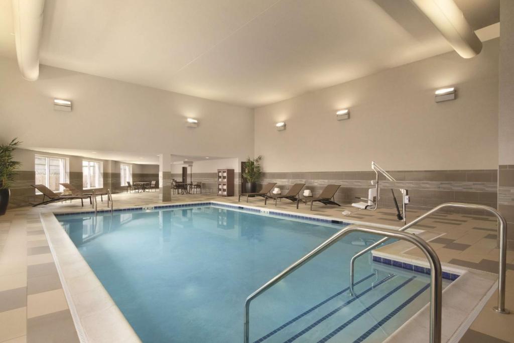 
a swimming pool with a swimming pool tub and chairs at Hyatt Place Chicago O'Hare Airport in Rosemont

