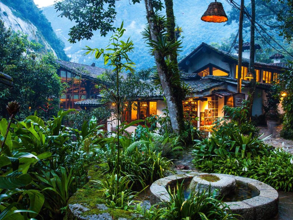 a house with a garden in front of it at Inkaterra Machu Picchu Pueblo Hotel in Machu Picchu