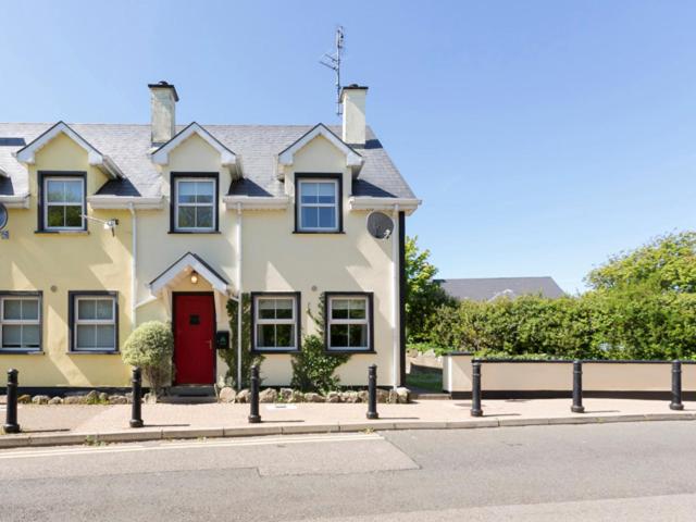 a large house with a red door on a street at 17 Mountaindale in Tullaghan