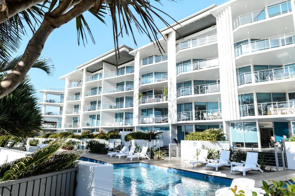 an image of a hotel with a swimming pool and palm trees at C Bargara Resort in Bargara