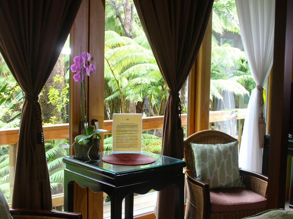 a room with a table and chairs and a window at At the Craters Edge in Volcano