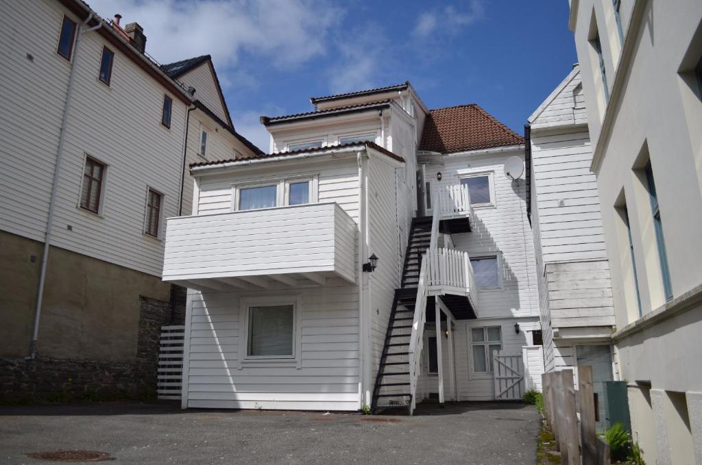 a white house with a staircase in front of it at LS Apartments in Bergen