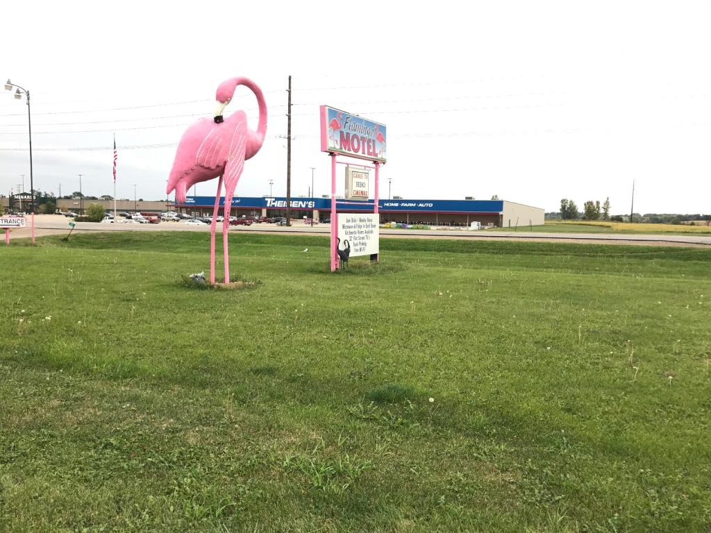 uma grande estátua de flamingo rosa no meio de um campo em Flamingo Motel Marshalltown em Marshalltown