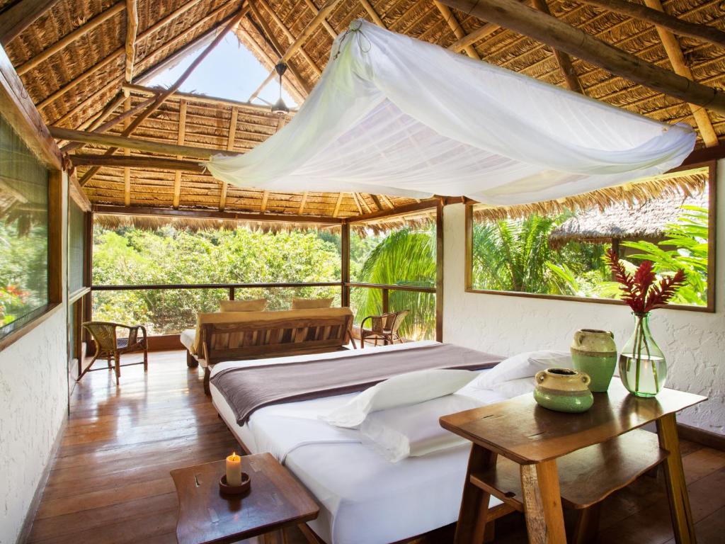 een slaapkamer in een villa met een bed en een tafel bij Inkaterra Hacienda Concepcion in Puerto Maldonado