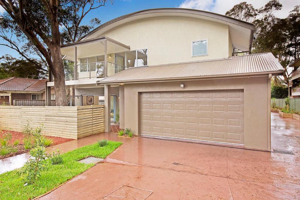 a large house with a garage in front of it at The Beach Townhouse in Hawks Nest