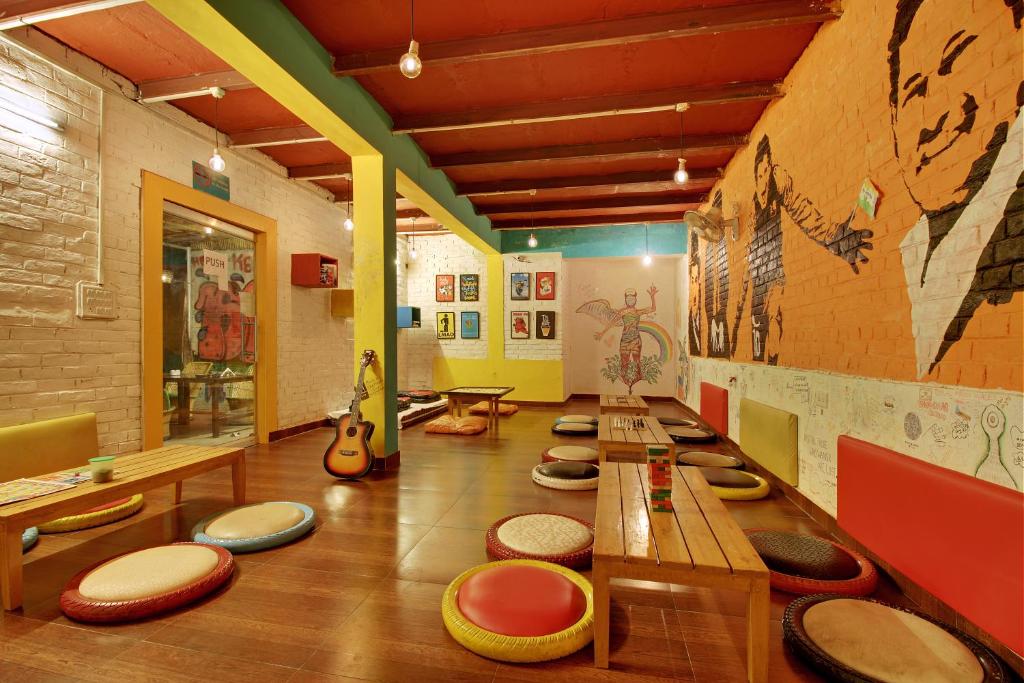 um quarto com um monte de mesas e cadeiras em Bedweiser Backpackers Hostel em Agra
