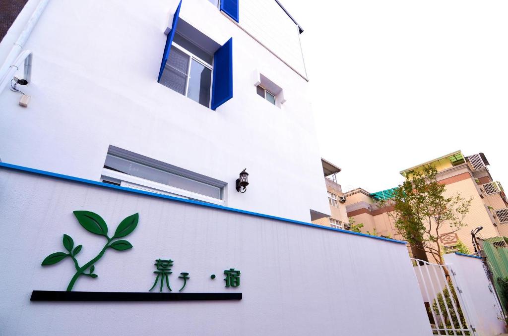un edificio blanco con plantas a su lado en Leaf Hostel, en Tainan