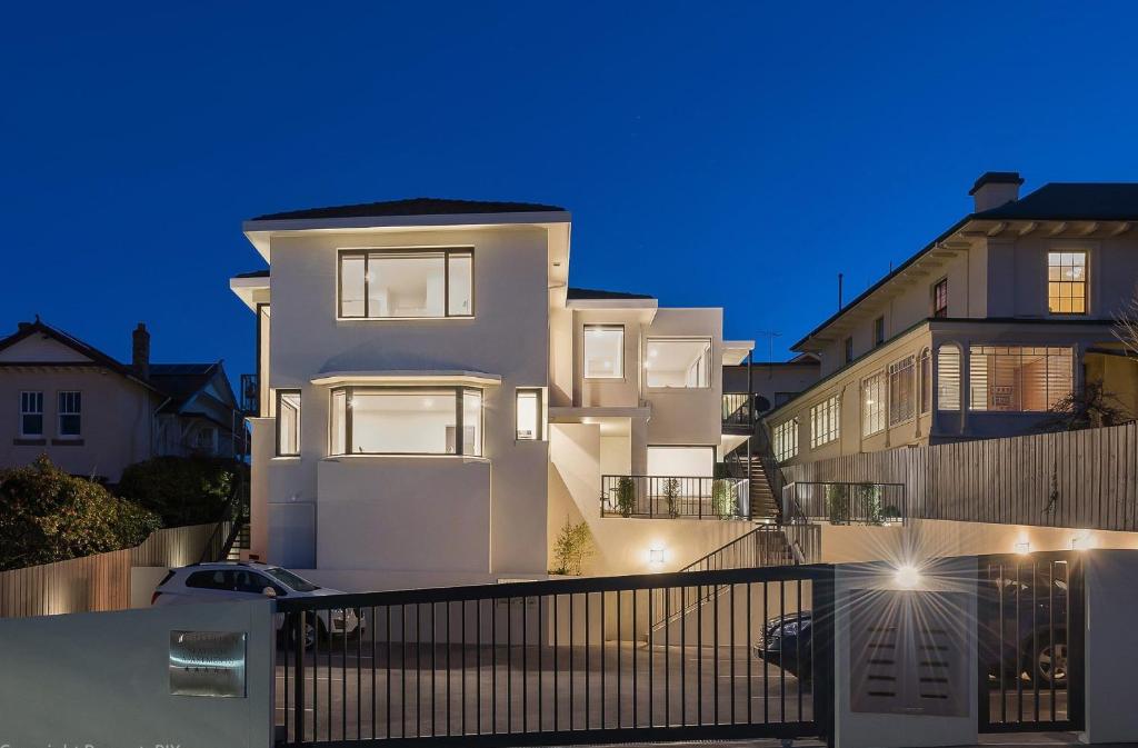 un edificio blanco con una valla delante en 110 Hampden Apartments, en Hobart