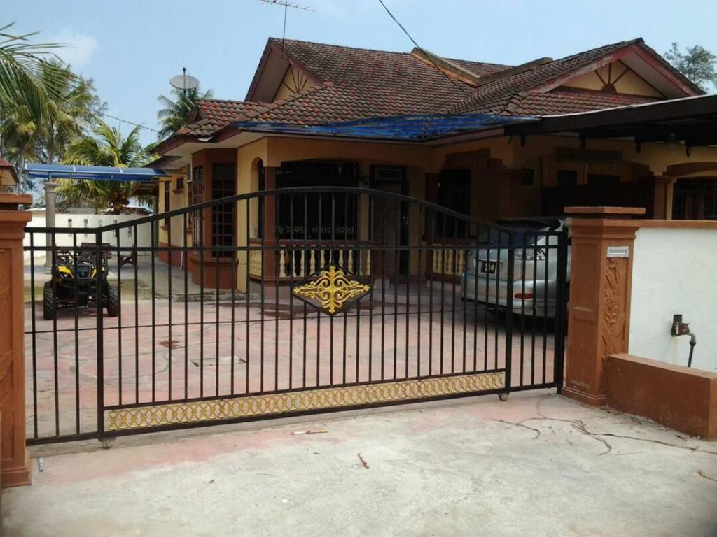 ein schwarzes schmiedeeisernes Tor vor einem Haus in der Unterkunft Beachland Guesthouse in Kuala Terengganu