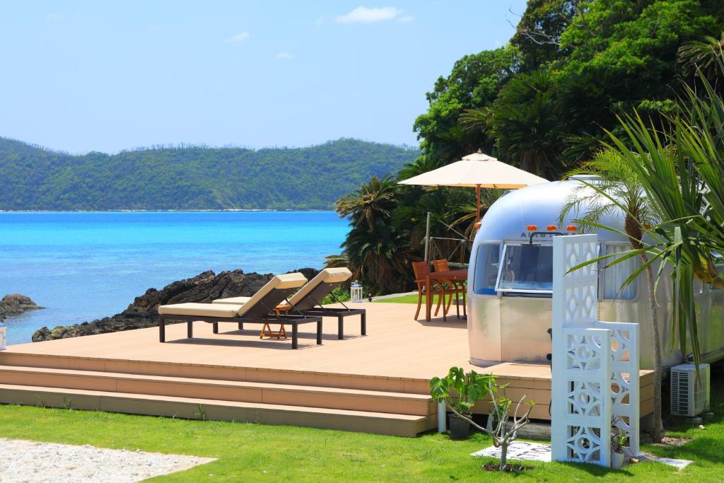 uma caravana estacionada ao lado de uma praia com o oceano em Holly Camp Airstream Villa Amami em Amami