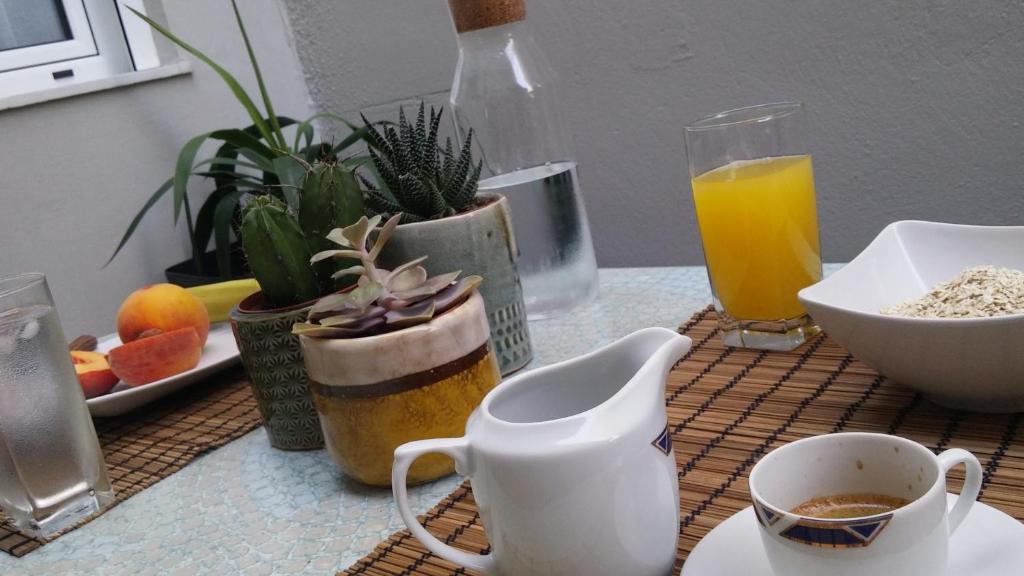 una mesa con plantas y una taza de café y zumo de naranja en Detached House at Peristeri, en Atenas