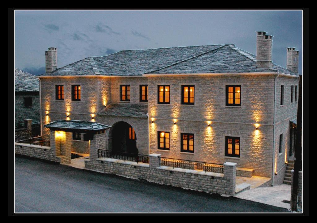 a large brick house with lights on it at Zagori Philoxenia Hotel in Monodendri