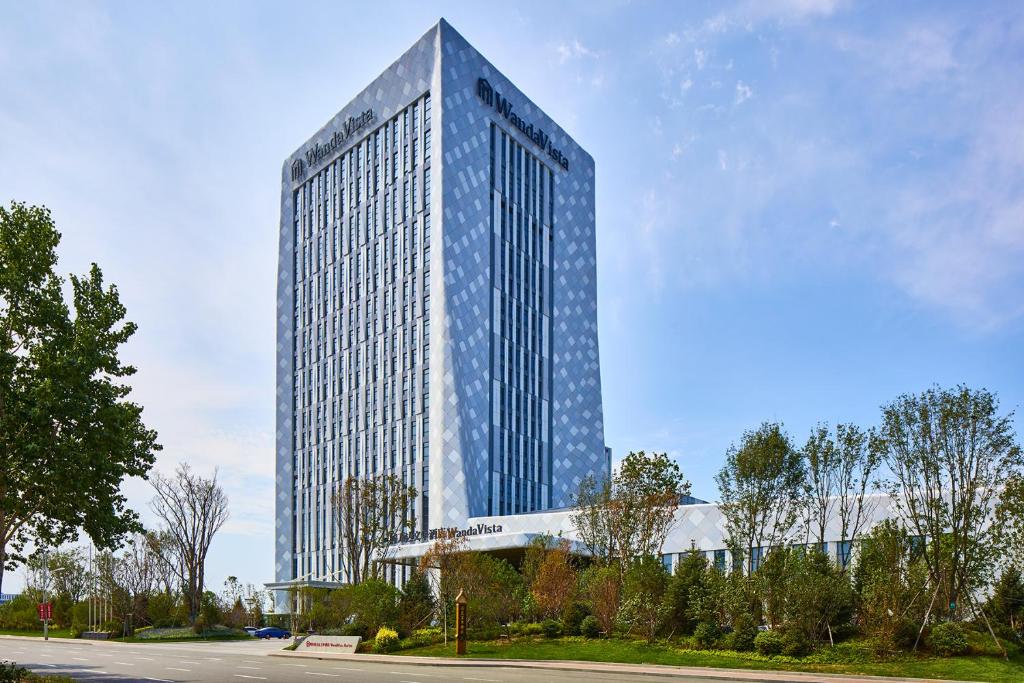 a tall building with a lot of windows at Wanda Vista Harbin in Harbin