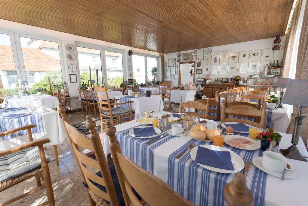 una sala da pranzo con tavolo e piatti blu e bianchi di Atlantic Hotel Garni a Wangerooge