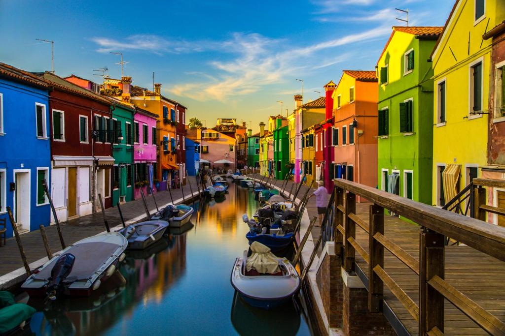 a group of boats in a canal with colorful buildings at Appartamento Ca' Tiziana - Venice - Jesolo in Musile di Piave
