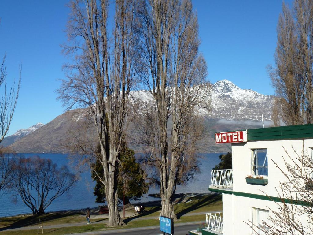 ein Hotel mit Blick auf das Wasser und die Berge in der Unterkunft Lakeside Motel in Queenstown
