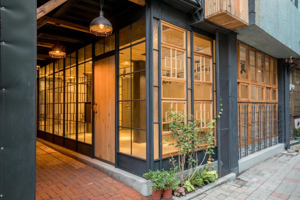 a store front with large windows and potted plants at Atreeium in Tainan