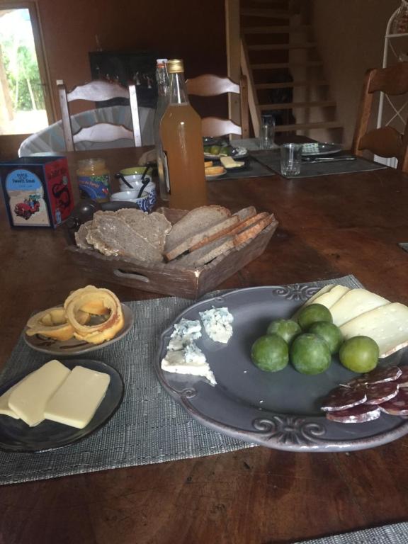 a table with a plate of cheese and other foods at Le Chat Blanc in Versols-et-Lapeyre